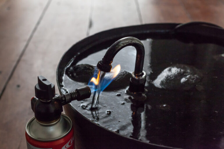 Lucy Andrews, Untitled, water, fountain pump, tap, bucket butane blowtorch, soot, 2015