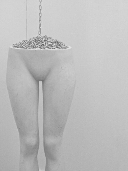 Sarah Lundy, Vessel [Fettered to Form], mannequin with chrome chain coiled in pelvic cavity extending to ceiling, compost at base, 2014